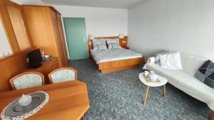 - un petit salon avec un lit et un canapé dans l'établissement Two Apartaments Almberg - Mitterdorf-Mitterfirmiansreut, à Mitterfirmiansreut