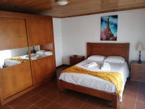a bedroom with a bed and a tower on the wall at Casa do Lajedo in Porto Martins