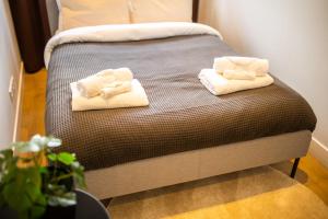 - un lit avec 2 serviettes assises au-dessus dans l'établissement Quality 2 Bedroom Serviced Apartment 72m2 -VP2A-, à Rotterdam