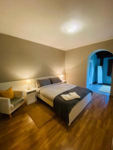 een slaapkamer met een groot bed en een stoel bij Chanel Garden Relaxation Home in Formello