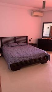 1 dormitorio con 1 cama grande y espejo en Au Bord du palmier, en Rabat