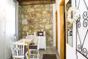 a dining room with a stone wall and a table and chairs at Tokaj Hill Panorama Guesthouse in Szerencs