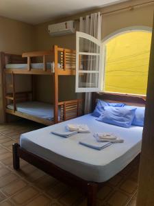 a bedroom with a bed with two bunk beds at O Mar Hospedagem - SUÍTES PRIVADAS in Arraial do Cabo