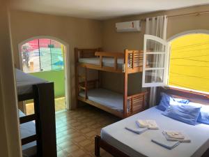 a room with a bed and a bunk room with a bed and a bunk bed at O Mar Hospedagem - SUÍTES PRIVADAS in Arraial do Cabo