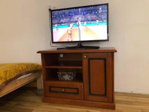 un televisor en un soporte de madera con un partido de baloncesto. en Gościniec Biebrzański en Lipsk