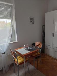 a table and chairs in a kitchen with a window at Donata in Osijek