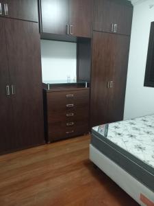 - une chambre avec un lit et des placards en bois dans l'établissement Apt na região central , Completo com 2 camas casal, à Patos de Minas