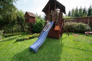 un pequeño parque infantil con un tobogán en un patio en Grabnicka Arkadia en Stare Juchy
