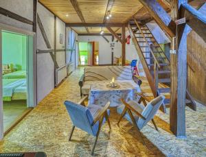 ein Zimmer mit einem Tisch, Stühlen und einer Treppe in der Unterkunft Grabnicka Arkadia in Stare Juchy