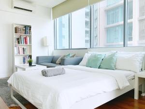 a large white bed in a room with a couch at Summer Suites Apartment @KLCC by Sarah's Lodge in Kuala Lumpur