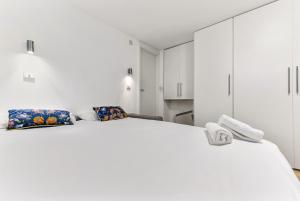 a white bedroom with a large white bed at Charlotte Street Rooms by News Hotel in London