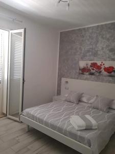 una camera bianca con letto e specchio di Appartamento nuovo a Lampedusa