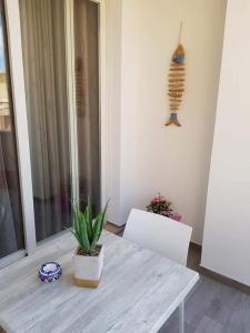 une table avec une plante en pot au-dessus d'une pièce dans l'établissement Appartamento nuovo, à Lampedusa