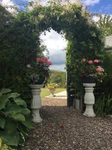 an archway with two vases filled with flowers at Balmungo Cottage B&B in St. Andrews