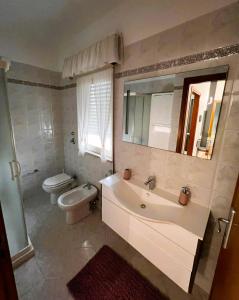 uma casa de banho com um lavatório, um WC e um espelho. em Nandrino em Trapani