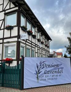 un bâtiment avec un panneau devant lui dans l'établissement Pension Lavendel, à Harztor
