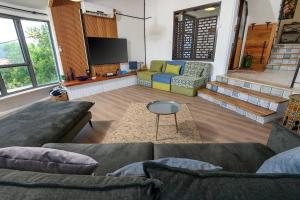 uma sala de estar com 2 sofás e uma televisão de ecrã plano em בית מול ירח em Ma'alot Tarshiha