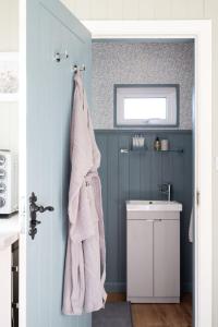 a bathroom with a sink and a towel hanging on the wall at Barfield Shepherds Hut in Magherafelt