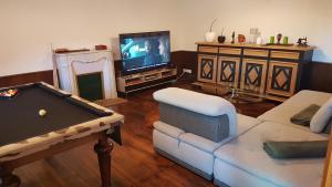 uma sala de estar com uma mesa de bilhar e uma televisão em Résidence de Suzanne Gîte avec sauna privatif em Brommat