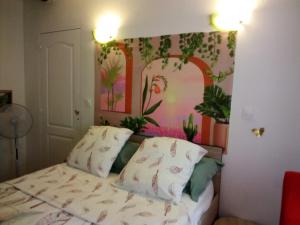 a bedroom with a bed with a painting on the wall at Les Abeilles in Signes