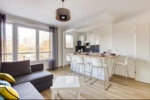a living room with a couch and a kitchen at 2 Appartements au Centre d'EVRY proches de PARIS in Courcouronnes