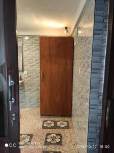 een badkamer met een houten deur en een tegelmuur bij TEGESWOODHOUSE A with WiFi,Ac in Ubud
