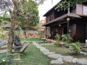 een tuin met een standbeeld voor een huis bij TEGESWOODHOUSE A with WiFi,Ac in Ubud