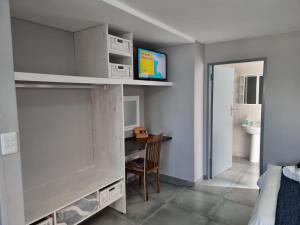 a small room with a desk and a bedroom at Langebaan Beach Towers in Langebaan