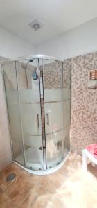 una doccia in vetro in una stanza con parete in mattoni di Casa Los Agapantos a Breña Alta