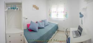 a bedroom with a bed with a laptop on it at EL HOGAR DEL MAGEC in Las Palmas de Gran Canaria