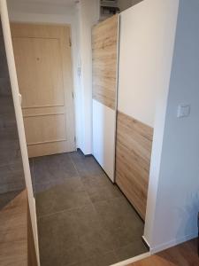 a room with a closet and a door and a tile floor at Zoo Karlovarská Apartment in Pilsen