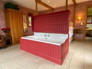 eine rote Badewanne in einem Zimmer mit einem Schlafzimmer in der Unterkunft The Green House in Glenelg