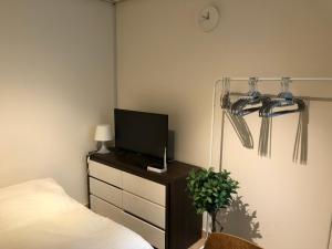 um quarto com uma cama e uma televisão numa cómoda em Rich House Dongdaemun em Seul