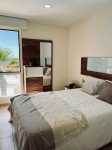 1 dormitorio con cama grande y ventana grande en Bella Vista en Poris de Abona