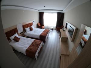 a hotel room with two beds and a television at Arhavi Resort Otel in Arhavi