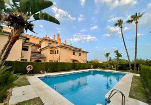 una piscina frente a una casa con palmeras en Royal Pearl Marbella, en Marbella