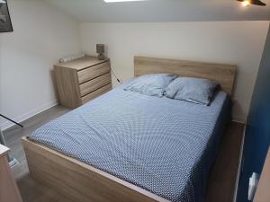 a bedroom with a bed and a night stand at F1 duplex Bleuet Rénové in Lamalou-les-Bains