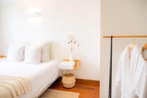 1 dormitorio con 1 cama con almohadas blancas en Madeira Precious Penthouse, en Funchal