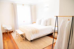 een slaapkamer met een wit bed en een raam bij Madeira Precious Penthouse in Funchal