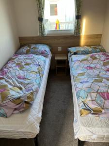 2 camas en una habitación con ventana en 709 Seawick, en Jaywick Sands