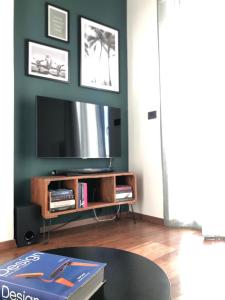 salon z telewizorem i stołem w obiekcie Blu Balena - appartamento piano attico con terrazze w mieście Tarent