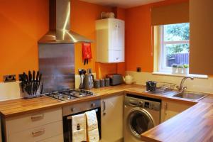 uma cozinha com uma máquina de lavar roupa e um lavatório em Cheery Craigie ground floor apartment em Perth