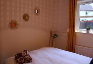 a bedroom with a white bed and a window at Cheery Craigie ground floor apartment in Perth