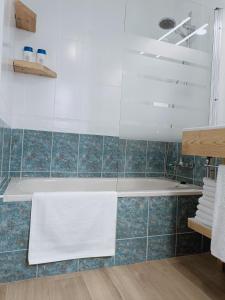 een badkamer met een bad en blauwe tegels bij TERRAZA AL MAR in Aguadulce