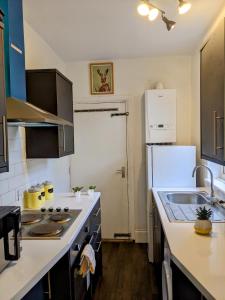 cocina con fregadero y nevera en CityHost Apartments - Newcastle, en Elswick