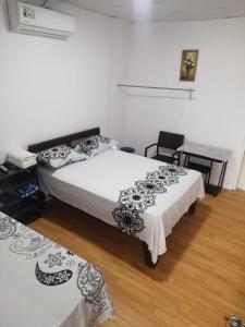 a bedroom with two beds and a table and chairs at Hostal My House Your House in David