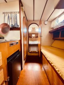 Kleines Zimmer mit einem Bett und einer Küche in der Unterkunft Stylish 80´s Fishing Boat in Barcelona