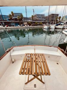 un banco de madera sentado en la parte trasera de un barco en Stylish 80´s Fishing Boat, en Barcelona