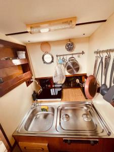un fregadero de acero inoxidable en una pequeña cocina en Stylish 80´s Fishing Boat, en Barcelona