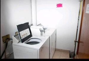 y baño con lavabo y lavadora. en Fun under the sun! en Cupecoy